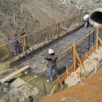 Workers building a support structure for a drainage culvert